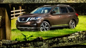 2019 Nissan Pathfinder driving by serene lake