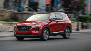 red Hyundai Santa Fe in motion down city street