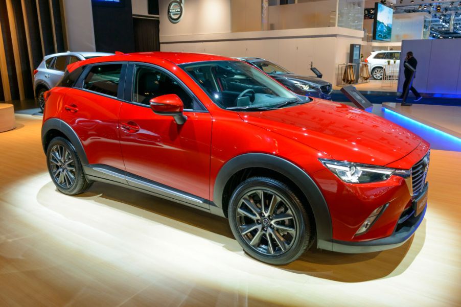 A red Mazda CX-3 in a showroom.