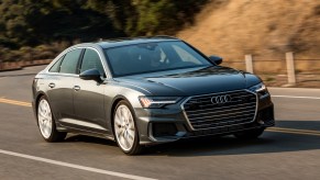 A grey Audi A6 sedan driving down the countryside.