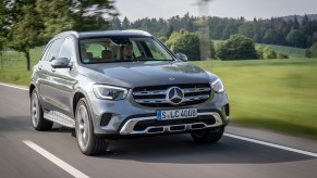 A chrome Mercedes-Benz GLC SUV driving down the road.