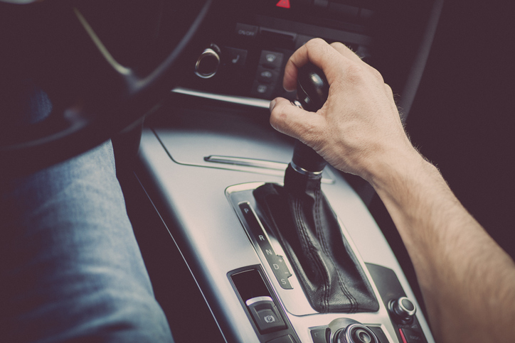 Male hand on gear shift in automatic transmission vehicle