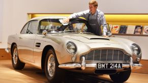 A man washes the front windshield of a 1965 Aston Martin DB5