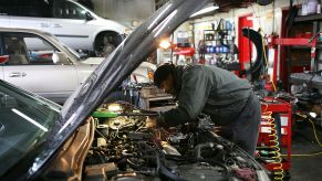 A driver uses an emergency roadside kit to repair his car.