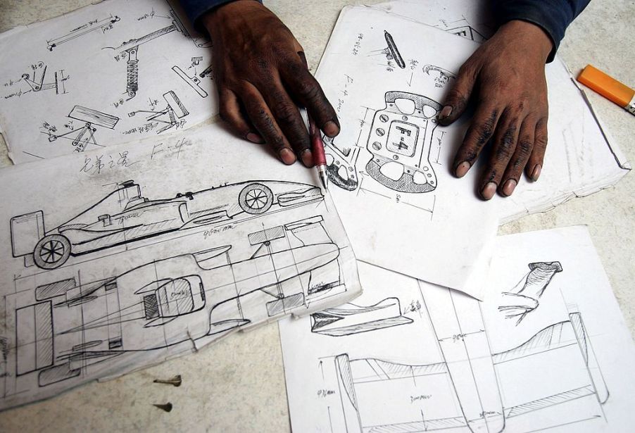 Car design blueprints spread out on a desk