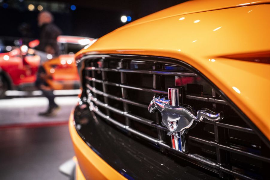 A logo is displayed on the front grille of a Ford Mustang during the 2019 New York International Auto Show