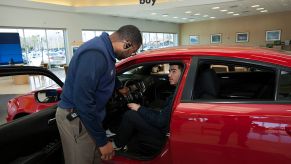 Finance and sales manager Warren Cox speaks with a customer about a Dodge Charger