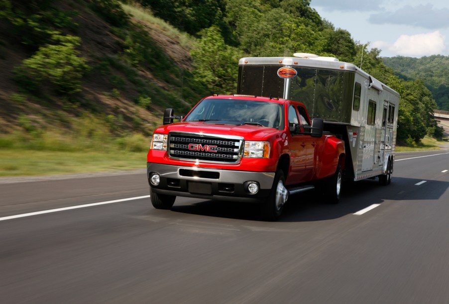 The 2013 GMC Sierra 3500 HD SLT pulls a horse trailer on a highway