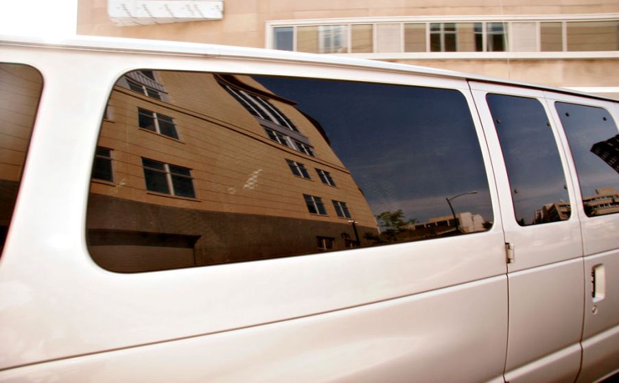 A van with dark tinted windows parked.