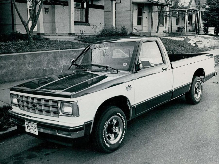 A black and white photo of a Chevy S10 parked on the street.