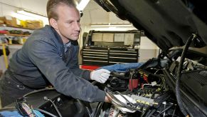 A mechanic inspecting the engine of a Chevy Silverado