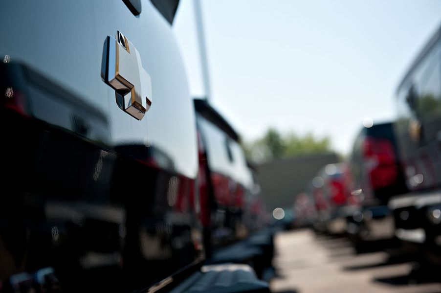 A car dealership lot with a row of Chevy trucks for sale.