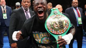 Deontay Wilder celebrating after defending his boxing championship belt