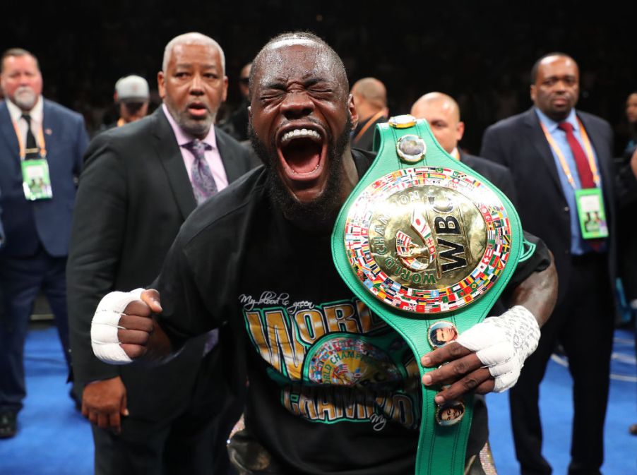 Deontay Wilder celebrating after defending his boxing championship belt