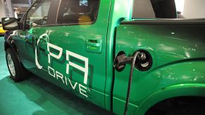 An electric Ford F-150 on display plugged into a charger.