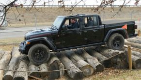 A Jeep Gladiator being test driven over a pile of logs.