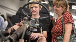 A boy and his mom learn about the chassis of a Chevy S10 truck