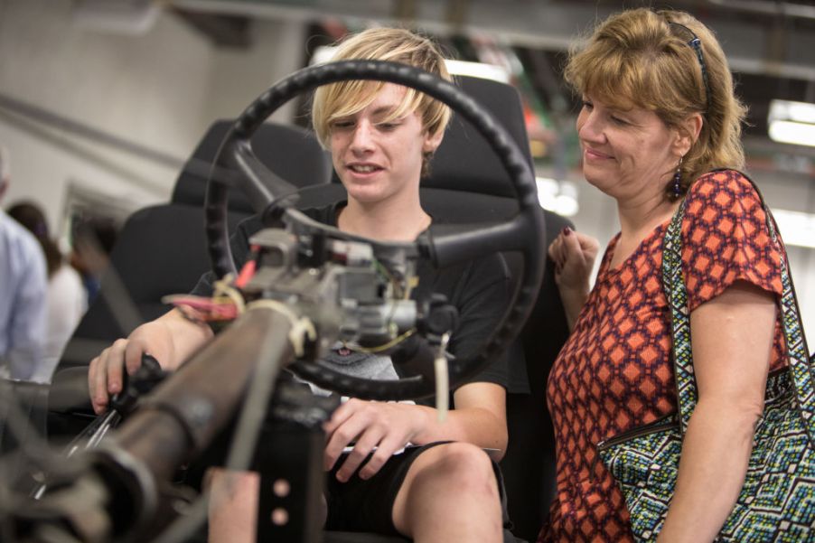 A boy and his mom learn about the chassis of a Chevy S10 truck