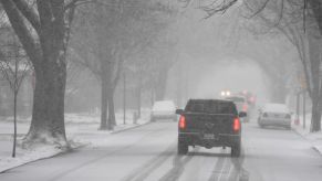 A truck drives down the road using its snow tires