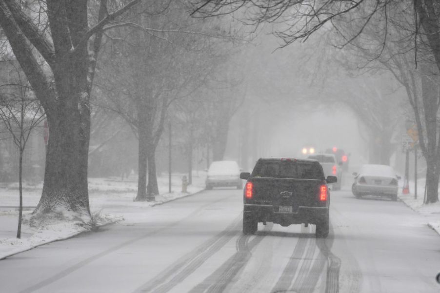 A truck drives down the road using its snow tires