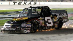 A racing truck skidding to a stop after a tire blowout.