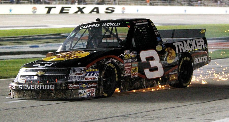 A racing truck skidding to a stop after a tire blowout.