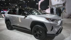 A silver Toyota RAV4 on display at an auto show.