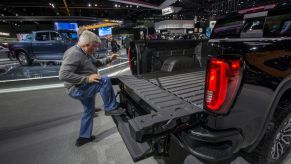 Man climbing up a truck tailgate at a demonstration.