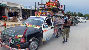 A pickup truck loaded with accessories is inspected by the police.