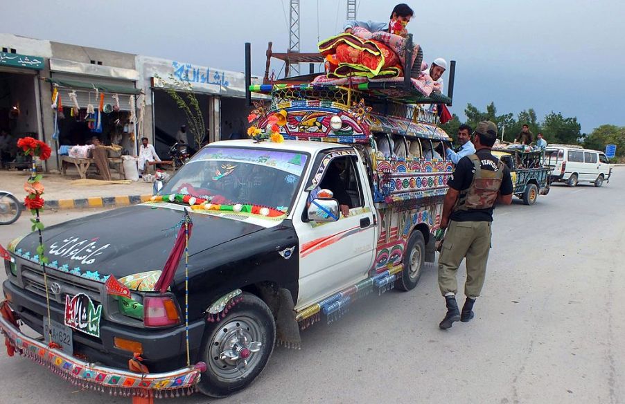 A pickup truck loaded with accessories is inspected by the police.