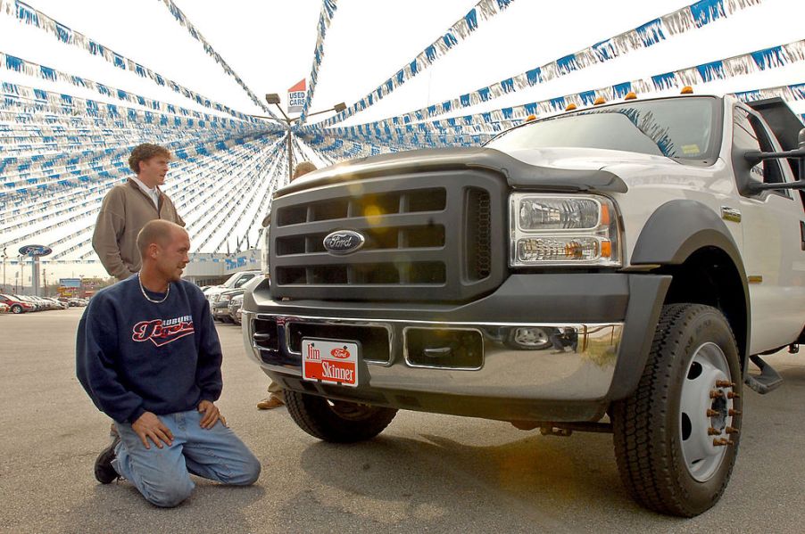 Sales associate shows a F-550 Ford truck to a potential buyer