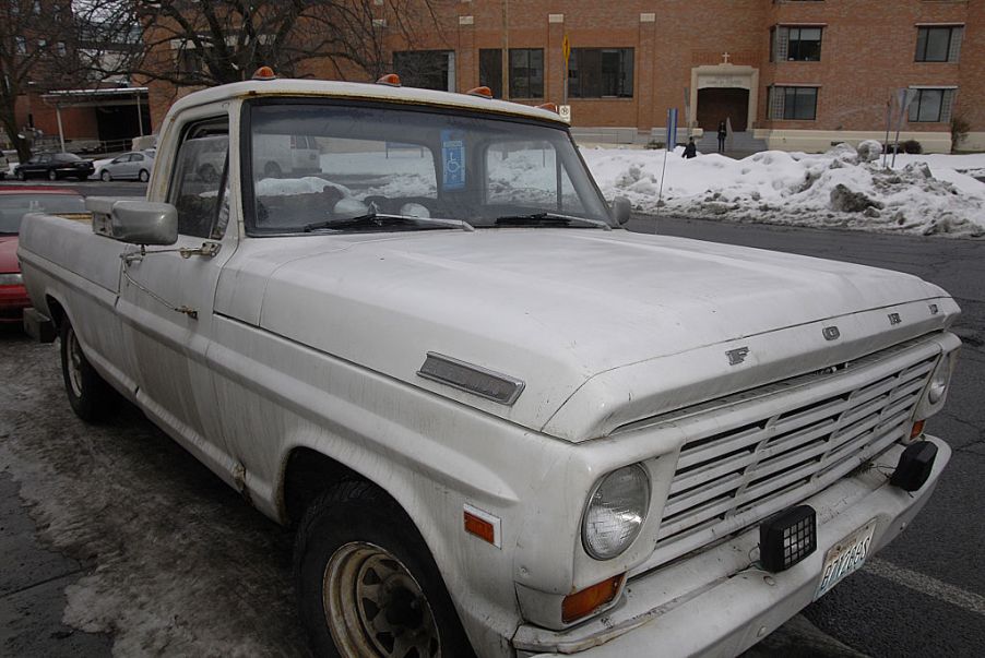 A used white Ford pickup truck parked on the road.