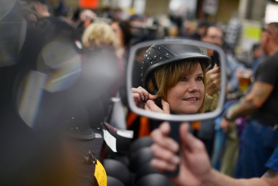 Woman tries on helmet at the Colorado Motorcycle Expo