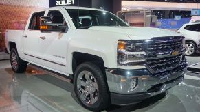 A white Chevy Silverado on display at an auto show.