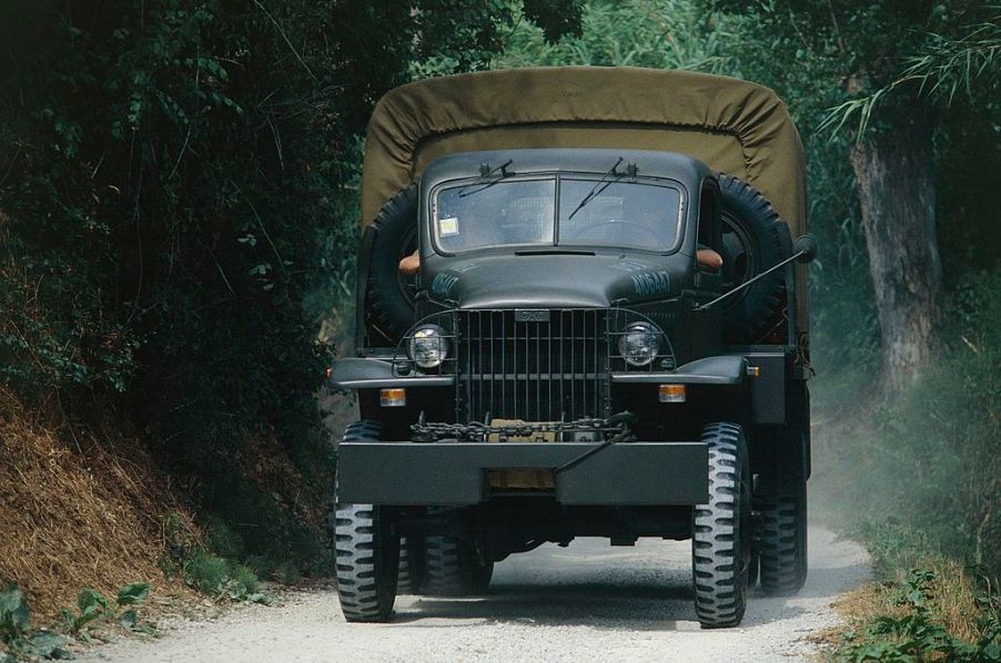 U.S. military vehicles, a 1942 GMC, drives down the road