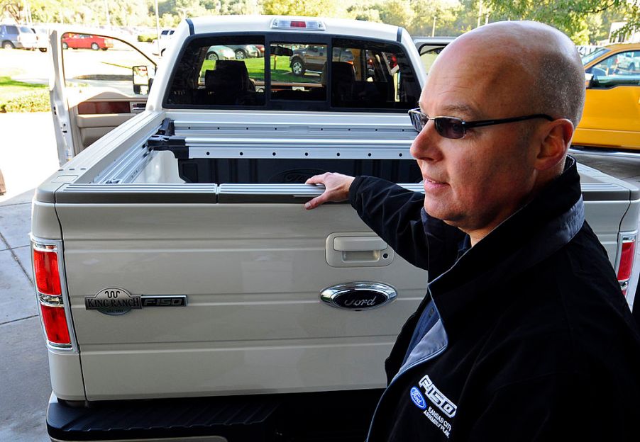 A man showing a used 2008 Ford F-150 pickup truck.