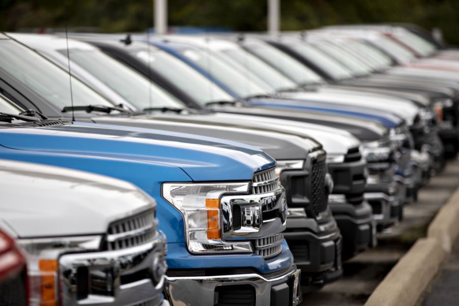 Ford F-150 trucks on display at a car dealership.