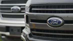 Two Ford trucks on display at an dealership.