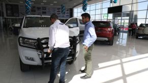 An employee shows a customer a Ford Ranger truck at a dealership