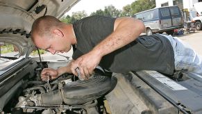 Service mechanic works on a truck engine