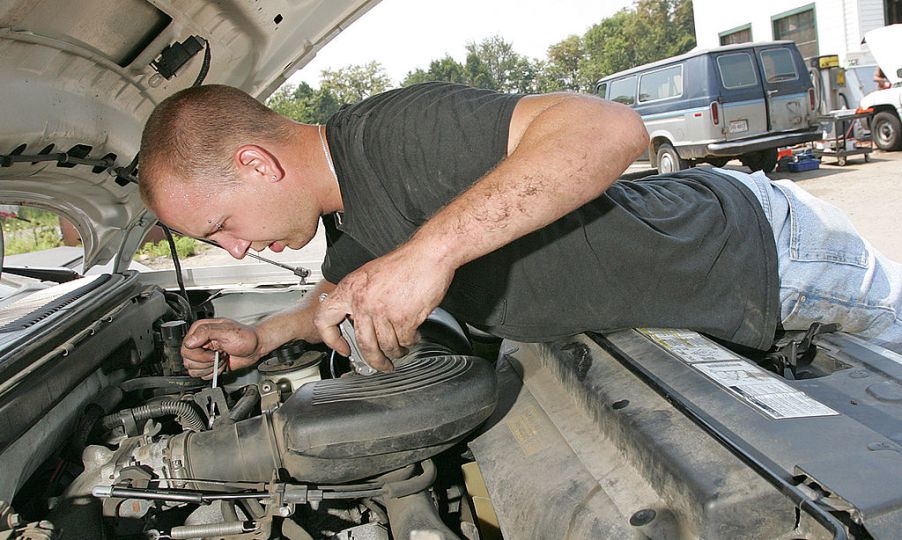 Service mechanic works on a truck engine