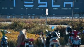 Motorcycles are parked next to the new Tesla factory built in Shanghai