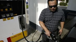 A man filing up his used pickup truck with gas.