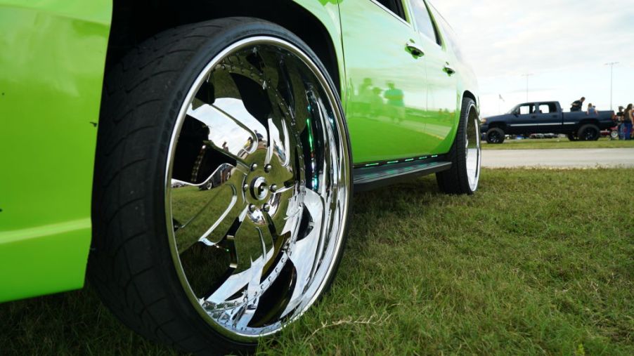 The rims of a truck reflect the Daytona Turkey Run car show