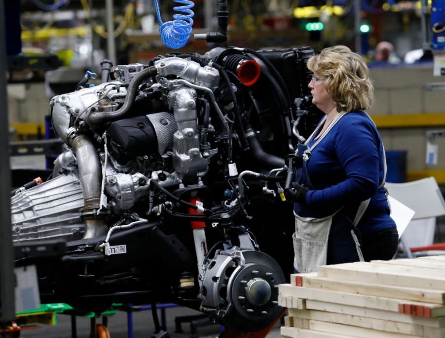 The Silverado and Sierra truck engine is inspected by a GM worker.