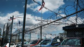 New cars sit in a lot at a Queens auto dealership