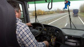 A trucker drives down the highway.