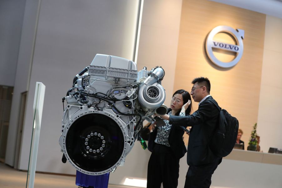 Attendees inspect a Volvo AB diesel truck engine