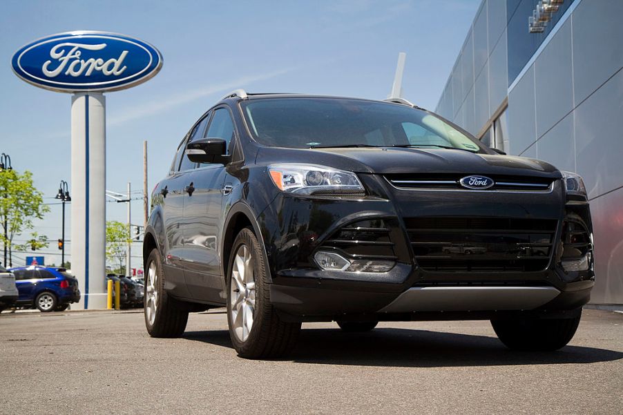 A 2014 Ford Escape on a car dealership lot.