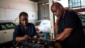 Two diesel mechanics repairing an engine